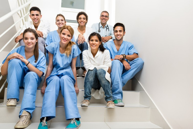 A group of nurses and health students sitting together on a staircase
